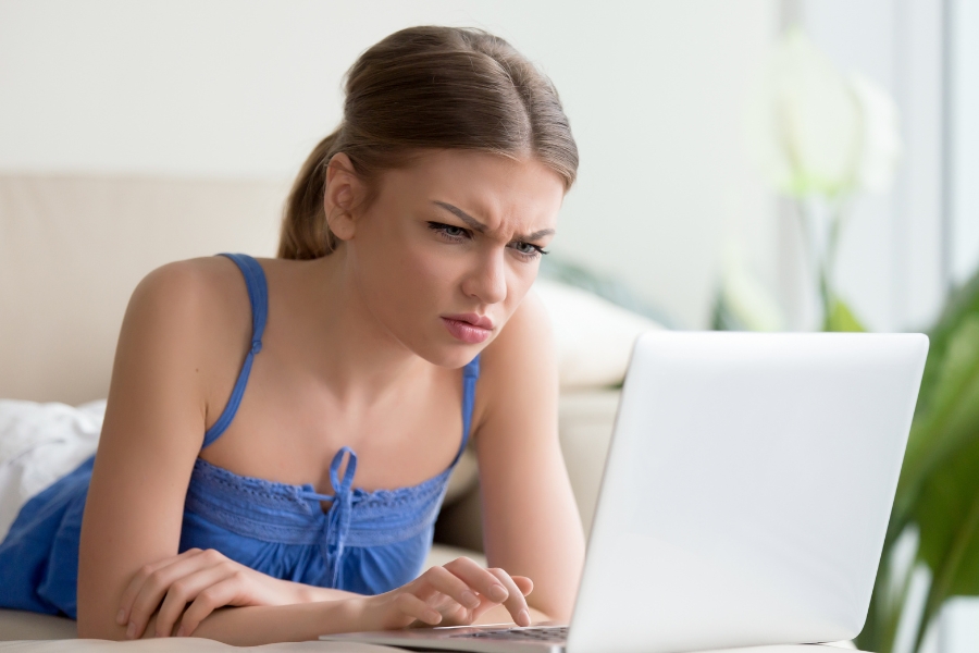 בחורה צעירה זעופת פנים מול מחשב נייד.